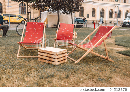 Wooden deck chairs on the grass in a garden street. Summer or weekend outdoor  94512876