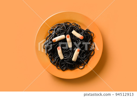 Halloween Italian black pasta decorated funny spiders in orange plate on orange . 94512913