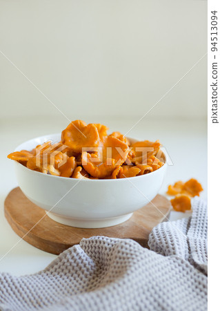 red chanterelle mushrooms in a white plate on a light gray table red chanterelle mushrooms in a white plate on a light gray table 94513094