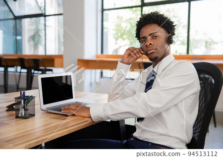 Focused male office worker with headset Focused male office worker with headset 94513112