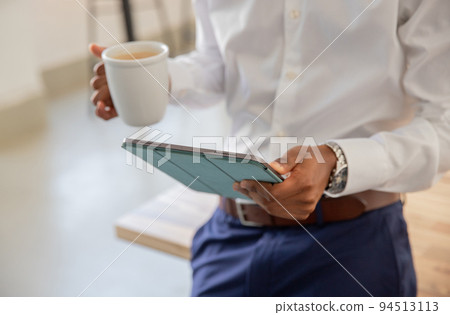 Close up of male hands with tablet and cup of coffee Close up of male hands with tablet and cup of coffee 94513113