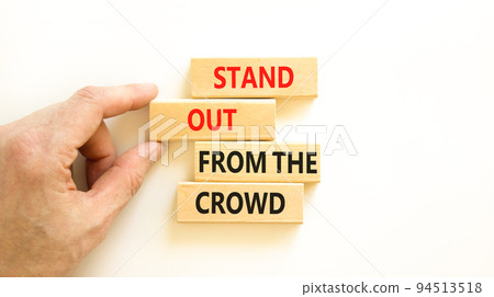 Stand out from the crowd symbol. Concept words Stand out from the crowd on wooden blocks on beautiful white table white background. Businessman hand. Business, stand out from the crowd concept 94513518