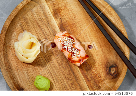 Sushi with smoked eel and sesame seeds on a wooden board. Japanese dish Unagi sushi. Sushi with smoked eel and sesame seeds on a wooden board. Japanese dish Unagi sushi. 94513876