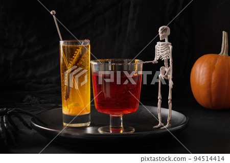 Halloween red and orange alcoholic cocktails decorated bat and skeleton on black. 94514414