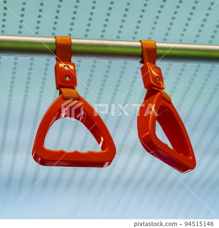 Close-up of red hanging plastic handles for standing passengers safety in public transportation 94515146