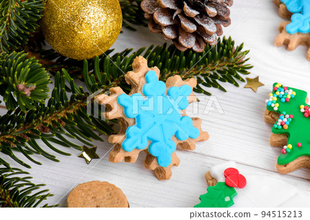 Tasty Christmas cookies, edible gift, fir branches, cones on wooden background, close up 94515213