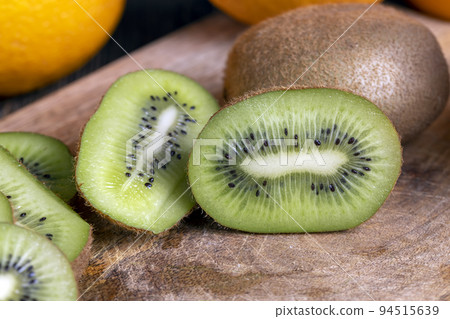 Sliced green kiwi fruit on a wooden board 94515639