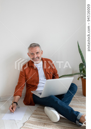 A bearded man in terracotta shirt working on the project and looking involved A bearded man in terracotta shirt working on the project and looking involved 94516009