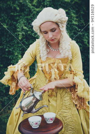 Portrait of blonde woman dressed in historical Baroque clothes with old fashion hairstyle, outdoors. Portrait of blonde woman dressed in historical Baroque clothes with old fashion hairstyle, outdoors. 94516029