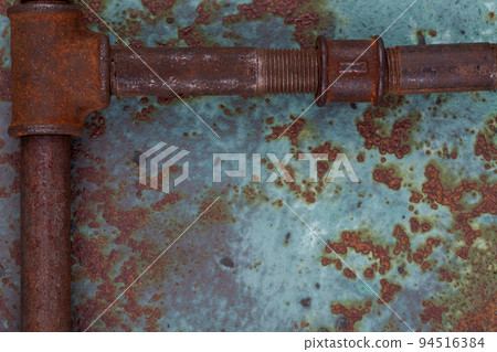 Old rusty valve pipes on rusty metal wall background 94516384