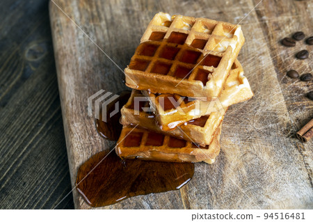 soft waffles with natural bee honey on a serving board 94516481