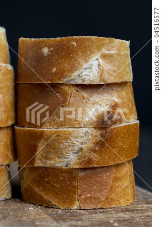 a wheat baguette cut into pieces, close up a wheat baguette cut into pieces, close up 94516577