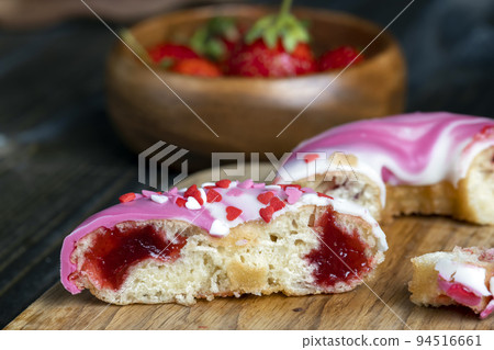round donuts in glaze and with berry filling 94516661