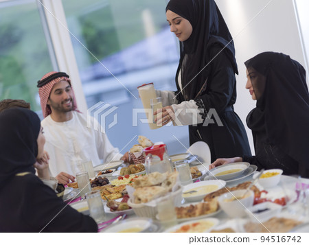 Eid Mubarak Muslim family having Iftar dinner drinking water to break feast. Eating traditional food during Ramadan feasting month at home. The Islamic Halal Eating and Drinking at modern western Isla Eid Mubarak Muslim family having Iftar dinner drinking water to break feast. Eating traditional food during Ramadan feasting month at home. The Islamic Halal Eating and Drinking at modern western Isla 94516742