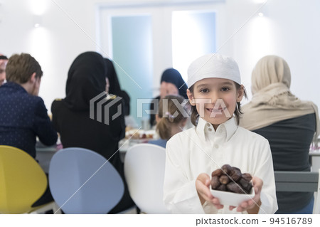 Eid Mubarak Muslim family having Iftar dinner little boy holding a plate full of sweet dates to break feast. Eating traditional food during Ramadan feasting month at home. The Islamic Halal Eating Eid Mubarak Muslim family having Iftar dinner little boy holding a plate full of sweet dates to break feast. Eating traditional food during Ramadan feasting month at home. The Islamic Halal Eating 94516789