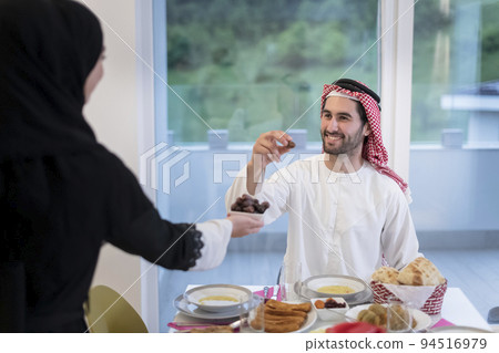 modern multiethnic muslim family sharing a bowl of dates while enjoying iftar dinner together during a ramadan feast at home modern multiethnic muslim family sharing a bowl of dates while enjoying iftar dinner together during a ramadan feast at home 94516979
