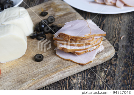 Fresh cow's milk cheese is cut on a board Fresh cow's milk cheese is cut on a board 94517048