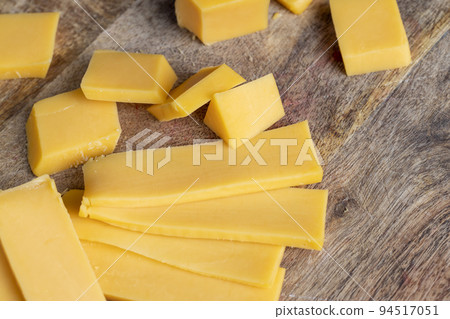 Sliced yellow cheese made from cow's milk Sliced yellow cheese made from cow's milk 94517051