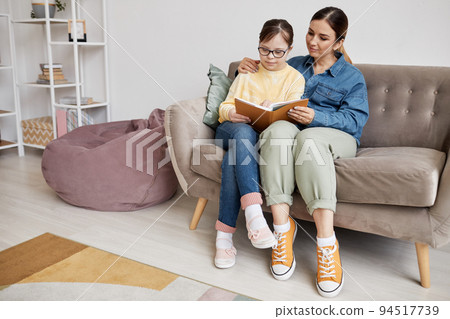 Mom And Daughter Reading Book At Home 94517739