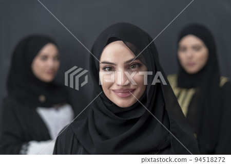 Group portrait of beautiful Muslim women in a fashionable dress with hijab isolated on black background Group portrait of beautiful Muslim women in a fashionable dress with hijab isolated on black background 94518272