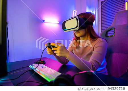 Gamer in VR headset glasses exploring metaverse play video game online with joystick 94520716