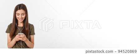 Portrait of a cheerful cute woman listening music in headphones and dancing isolated on a white background. 94520869