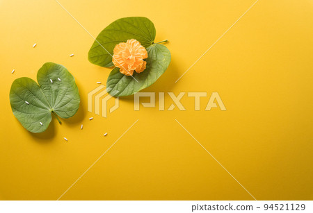 Happy Dussehra. Yellow flowers, green leaf and rice on yellow paper background. Dussehra Indian Festival concept. 94521129