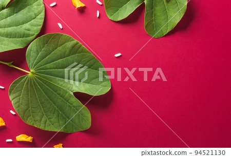 Happy Dussehra. Yellow flowers, green leaf and rice on red paper background. Dussehra Indian Festival concept. Happy Dussehra. Yellow flowers, green leaf and rice on red paper background. Dussehra Indian Festival concept. 94521130