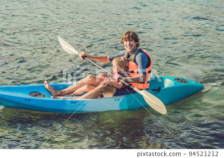 Father and son kayaking at tropical ocean. 94521212