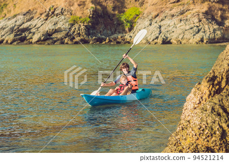 Father and son kayaking at tropical ocean. 94521214