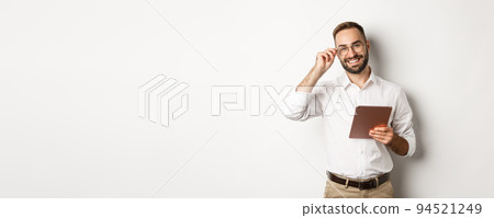 Confident business man working on digital tablet, smiling happy, standing over white background Confident business man working on digital tablet, smiling happy, standing over white background 94521249