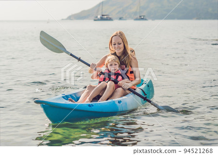 Mother and son kayaking at tropical ocean. 94521268