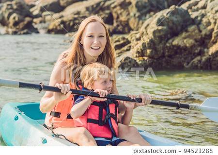 Mother and son kayaking at tropical ocean. Mother and son kayaking at tropical ocean. 94521288