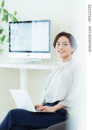 Business woman operating a laptop computer Business woman operating a laptop computer 94522395