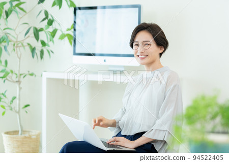 Business woman operating a laptop computer Business woman operating a laptop computer 94522405