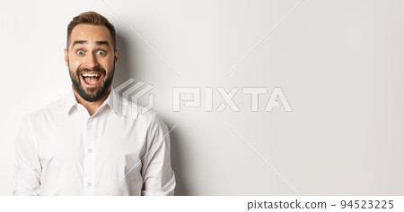 Close-up of caucasian bearded man looking excited, standing amazed against white background 94523225