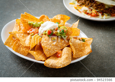 nachos tortilla chips with jalapeno, guacamole, tomatoes salsa and dip nachos tortilla chips with jalapeno, guacamole, tomatoes salsa and dip 94523566