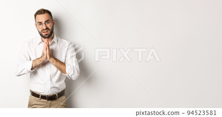 Worried man asking for help, begging for favour, standing over white background 94523581