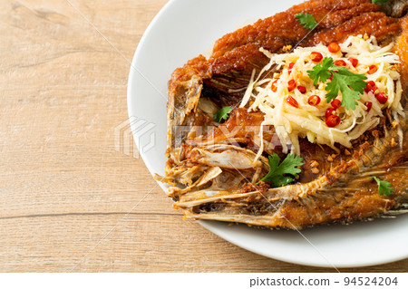 Fried Sea Bass Fish with Fish Sauce and Spicy Salad 94524204