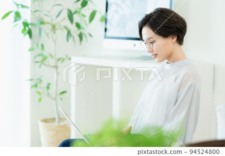 Business woman operating a laptop computer Business woman operating a laptop computer 94524800