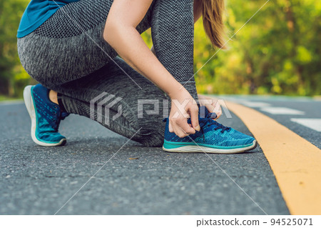 Female runner tying her shoes preparing for jogging outside .Young girld runner getting ready for training. Sport lifestyle 94525071