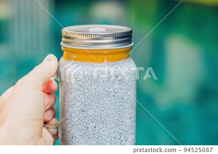 Healthy layered dessert with chia pudding and mango morning on the background of the pool 94525087