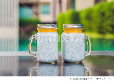 Healthy layered dessert with chia pudding and mango morning on the background of the pool Healthy layered dessert with chia pudding and mango morning on the background of the pool 94525088