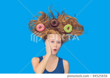 Young woman with donuts in her hair. Multicolored donuts. Harm of sweet 94525656