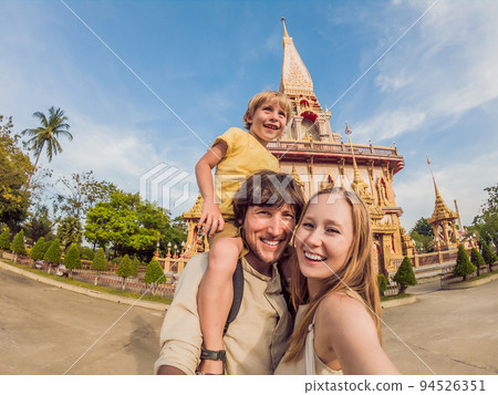 A happy family of tourists on the background of Wat Chalong in Thailand. Traveling with children concept 94526351