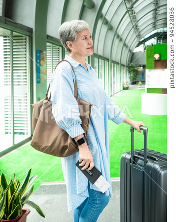 Portrait of senior adult elderly asian woman 60s smiling standing with suitcase luggage bag and holding passport with ticket for travel concept. Portrait of senior adult elderly asian woman 60s smiling standing with suitcase luggage bag and holding passport with ticket for travel concept. 94528036