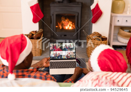 African american couple in santa hats on christmas video call with family African american couple in santa hats on christmas video call with family 94529645