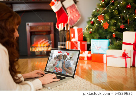 Caucasian woman on christmas laptop video call with african american couple 94529685