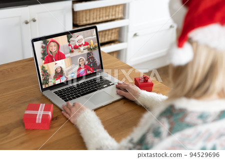Caucasian woman on christmas laptop video call with caucasian group of children Caucasian woman on christmas laptop video call with caucasian group of children 94529696