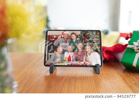 Happy caucasian multi generation family at christmas smiling on tablet video call interface screen 94529777